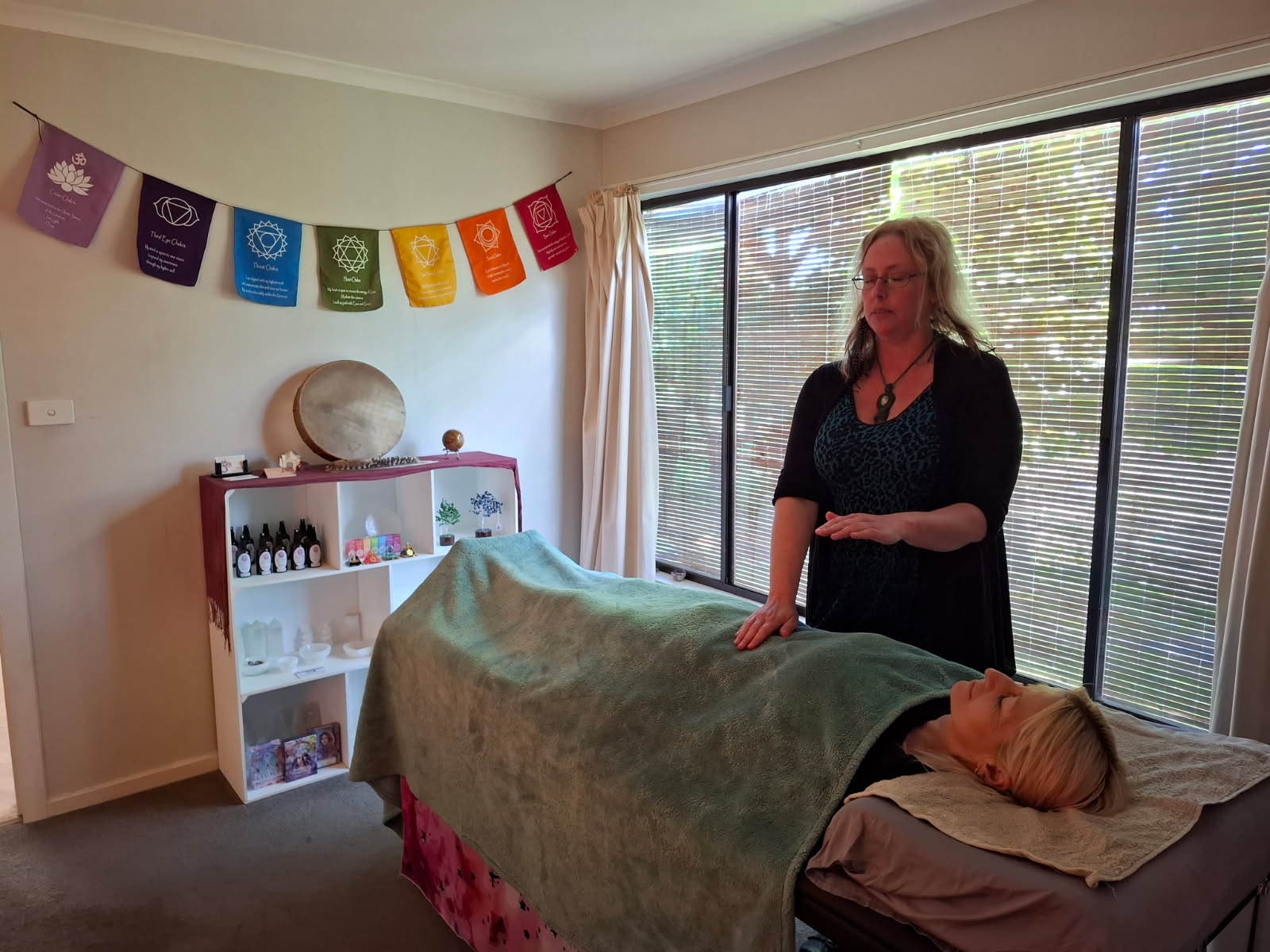 Alana Pearse, Reiki Master at Earth Aya Energy, giving a hands-on Reiki healing treatment to a client in her Healesville treatment room, Yarra Valley
