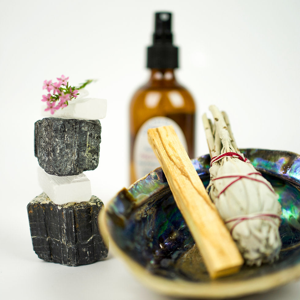 Earth Aya Energy gift shop — black tourmaline and selenite crystals, palo santo, white sage smudge stick, abalone shell and protection aura spray
