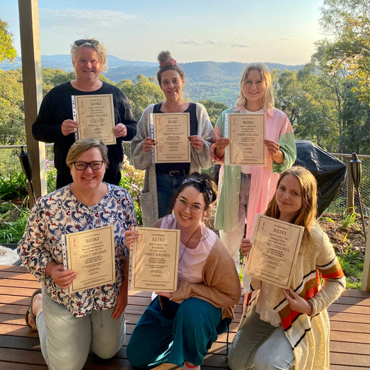Reiki Level 1 Graduates holding their certificates with view of the valley from Earth Aya Energy's front deck 