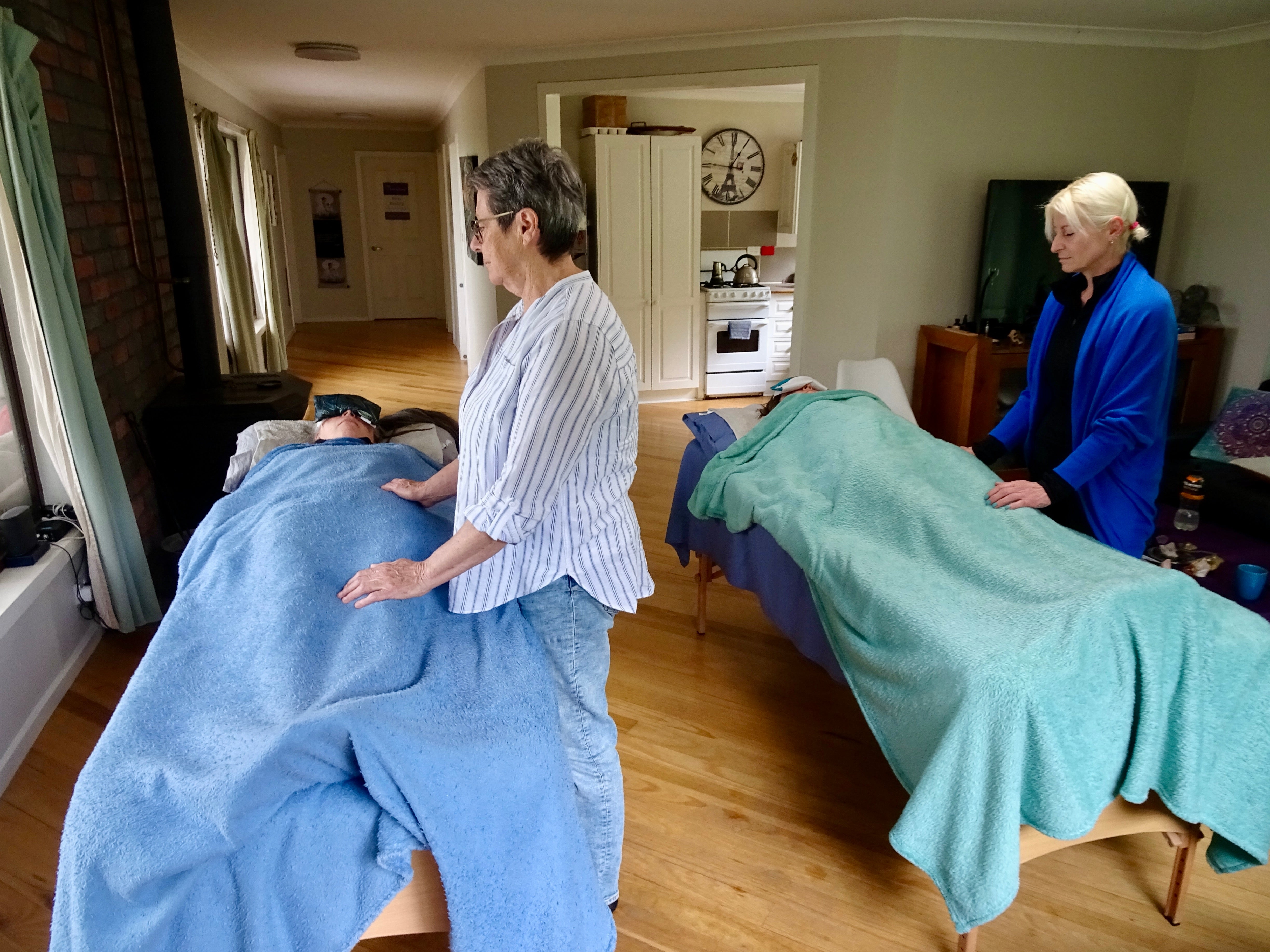 Reiki practitioners giving a healing treatment to a fellow student at a Reiki Share circle, Healesville VIC