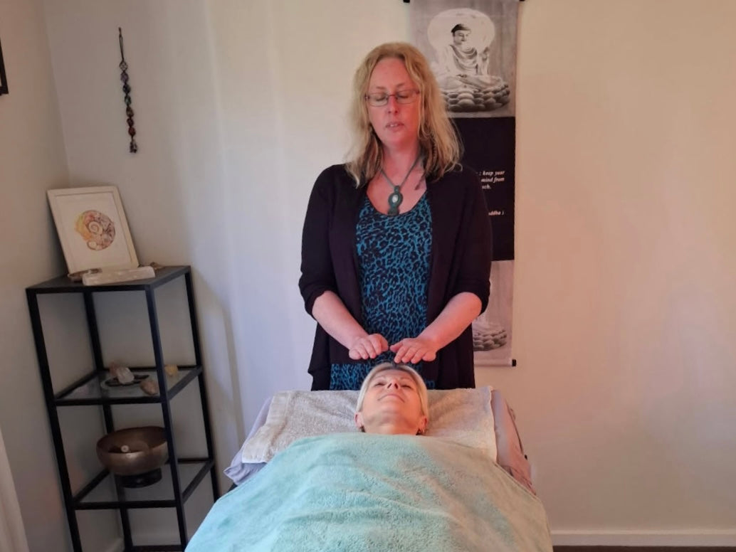 Alana Pearse, Reiki Master at Earth Aya Energy, performing a Reiki head treatment on a client lying on a massage table in Healesville, Yarra Valley