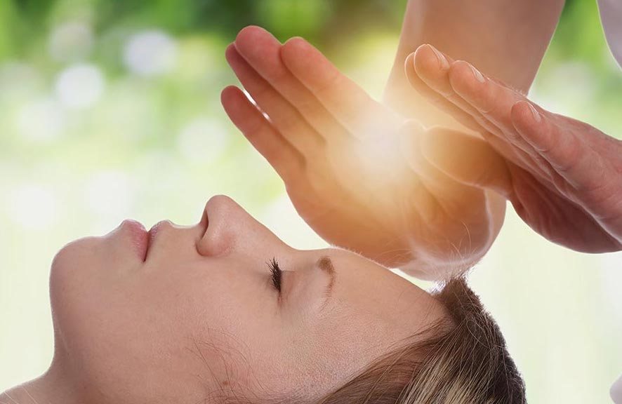 Reiki healing session — practitioner channelling healing energy over a client's head, Healesville Yarra Valley — Earth Aya Energy