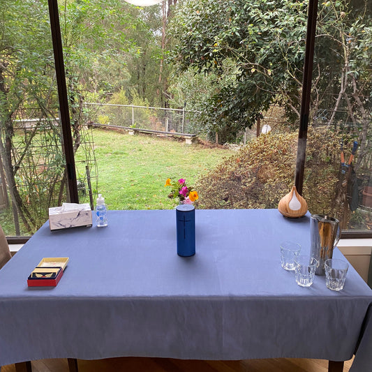 Welcoming table set up for a Reiki Share class at Earth Aya Energy — angel cards, music speaker, flowers, essential oil diffuser, and water for students, with a view of the garden in Healesville
